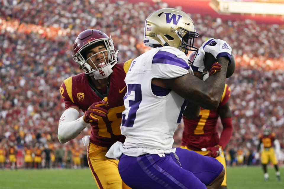 Washington tight end Devin Culp, right, scores a touchdown as Southern California linebacker Eric Gentry defends during the first half of an NCAA college football game Saturday, Nov. 4, 2023, in Los Angeles. (AP Photo/Ryan Sun)