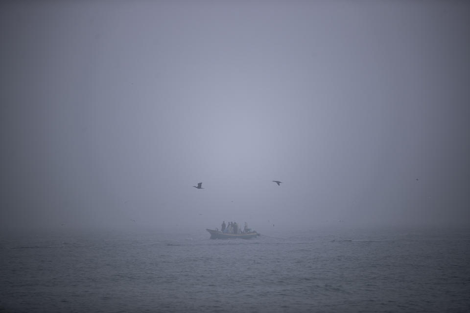 Palestinians collect their fishing net during a foggy morning off the beach of Gaza City, Tuesday, Jan. 5, 2021. Off the coast of the Gaza Strip, Palestinian fishermen have been in constant conflict with Israeli security forces. (AP Photo/Khalil Hamra)