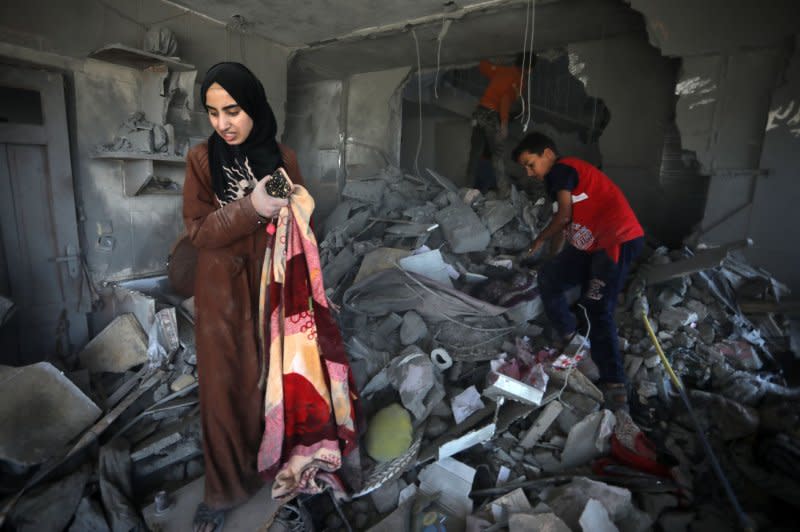 Palestinians take what is left of their belongings from their destroyed house following overnight Israeli airstrikes in the city of Rafah, southern Gaza Strip, on April 20. Photo by Ismael Mohamad/UPI