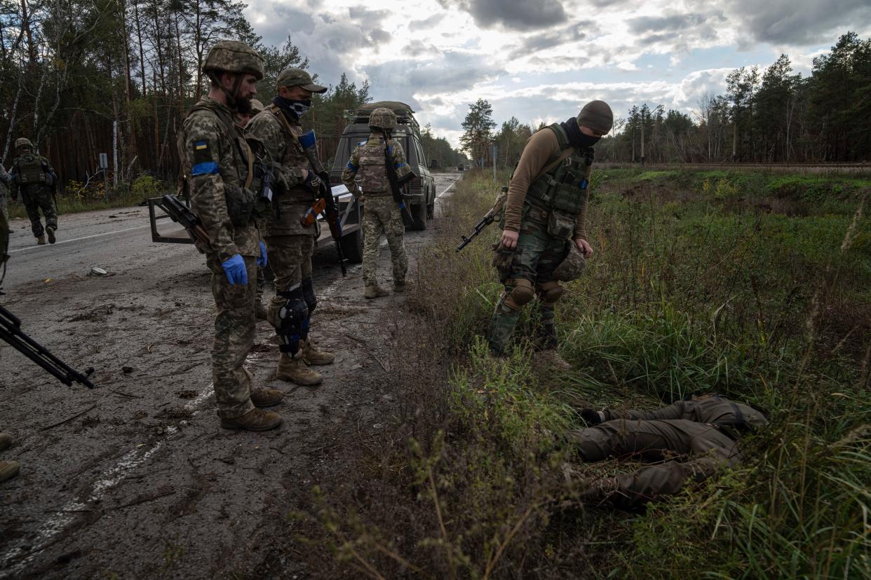 Ukrainian servicemen find a dead body while they search for comrades killed in fighting in the recently recaptured town of Lyman, Ukraine, Monday, Oct. 3, 2022.