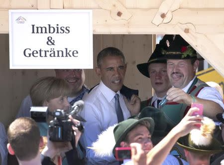 U.S. President Barack Obama and German Chancellor Angela Merkel meet people dressed in traditional Bavarian attire as they walk the streets of Kruen, Germany June 7, 2015. REUTERS/Daniel Karmann/Pool