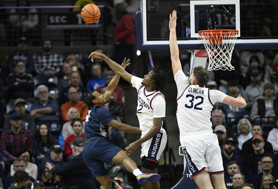 UConn guard Tristen Newton (2) blocks a shot by New Hampshire guard Ahmad Robinson (4) as UConn center Donovan Clingan (32) defends in the first half of an NCAA college basketball game, Monday, Nov. 27, 2023, in Storrs, Conn. (AP Photo/Jessica Hill)