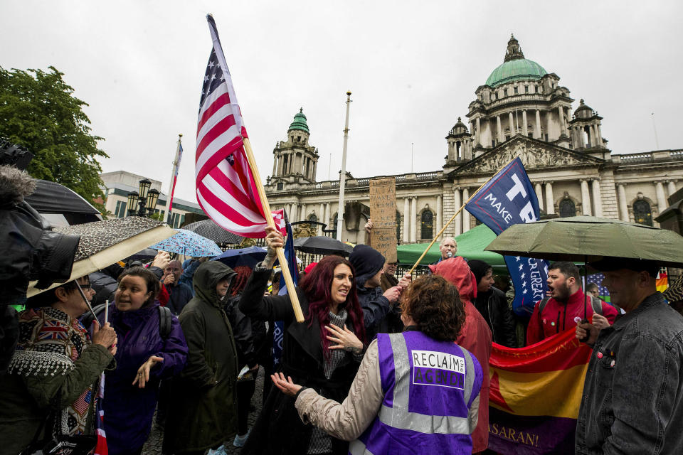 Jayda Fransen former deputy leader of Britain First, centre holds a US flag, as she stages a corner protest with supporters at a "Stop Trumpism" rally hosted by ExAct: Expat Action Group NI, at Belfast City Hall, in Belfast, Northern Ireland, Tuesday June 4, 2019. (Liam McBurney/PA via AP)