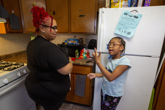 Ke'Arrah Jessie, 9, spends time in the kitchen with her mom, Ashley Martin, in Niagara Falls, N.Y., on Monday, April 3, 2023. (AP Photo/Lauren Petracca)