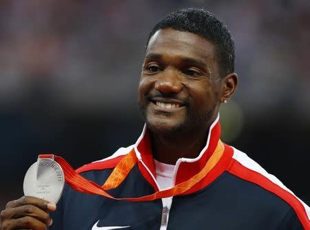 Justin Gatlin of the U.S. presents his silver medal as he poses on the podium after the men's 200 metres event during the 15th IAAF World Championships at the National Stadium in Beijing, China, August 28, 2015. REUTERS/Damir Sagolj