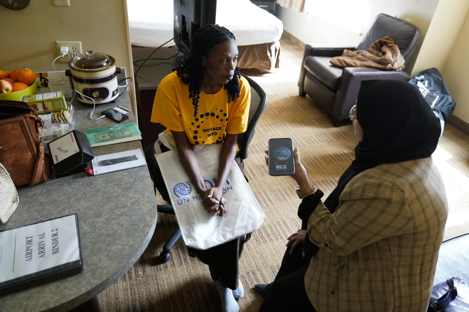 Congo refugee Aline Mugabekazi, left, with Lutheran Services Carolinas case manager Raja Alshuaibi, communicate with each other through an interpreter on the phone, Wednesday, April 17, 2024, in Columbia, S.C. The American refugee program, which long served as a haven for people fleeing violence around the world, is rebounding from years of dwindling arrivals under former President Donald Trump. The Biden administration has worked to restaff refugee resettlement agencies and streamline the process of vetting and placing people in America. (AP Photo/Erik Verduzco)