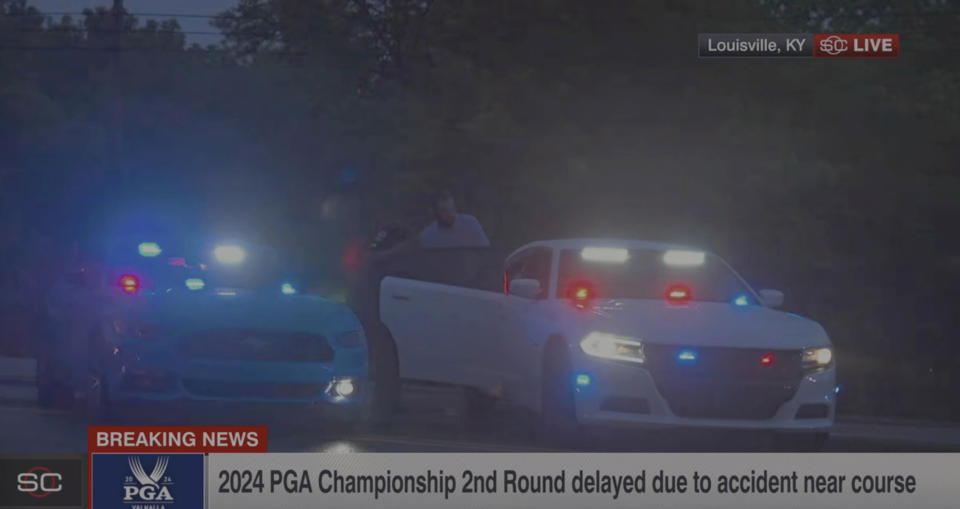 In this still image made from video provided by ESPN, Masters champion Scottie Scheffler is escorted to a police car after being handcuffed near Valhalla Golf Club, site of the PGA Championship golf tournament, early Friday, May 17, 2024. (ESPN via AP)