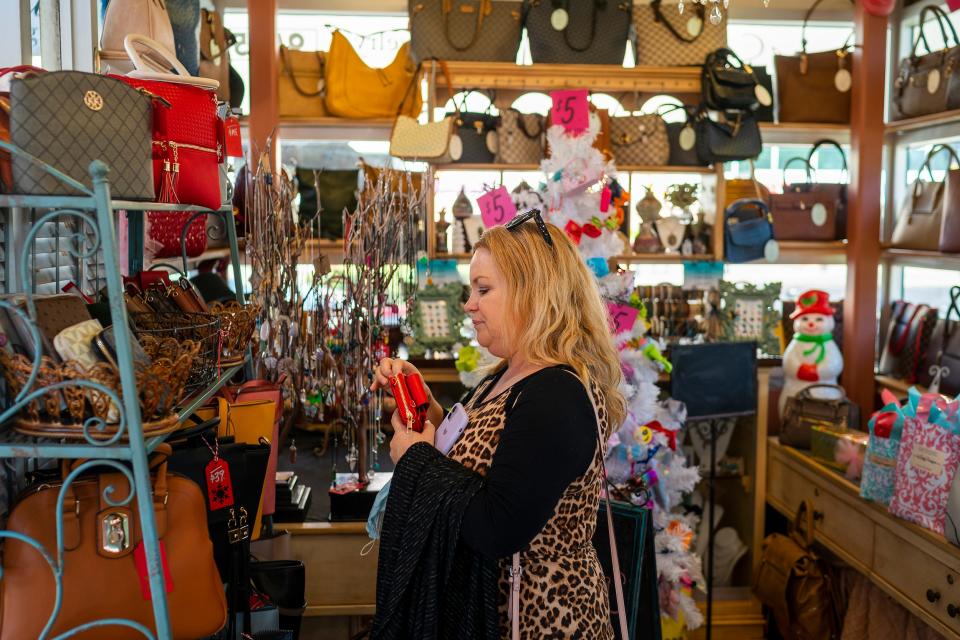 Teresa Swift-Jarrett shops for designer handbags at La Lady Designs on Black Friday at Westgate Entertainment District on Friday, Nov. 26, 2021, in Glendale.