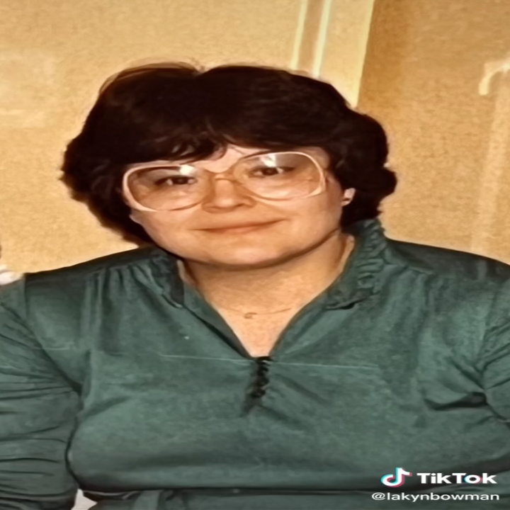 Lakyn's grandma poses for a photo in a green top and large trendy glasses