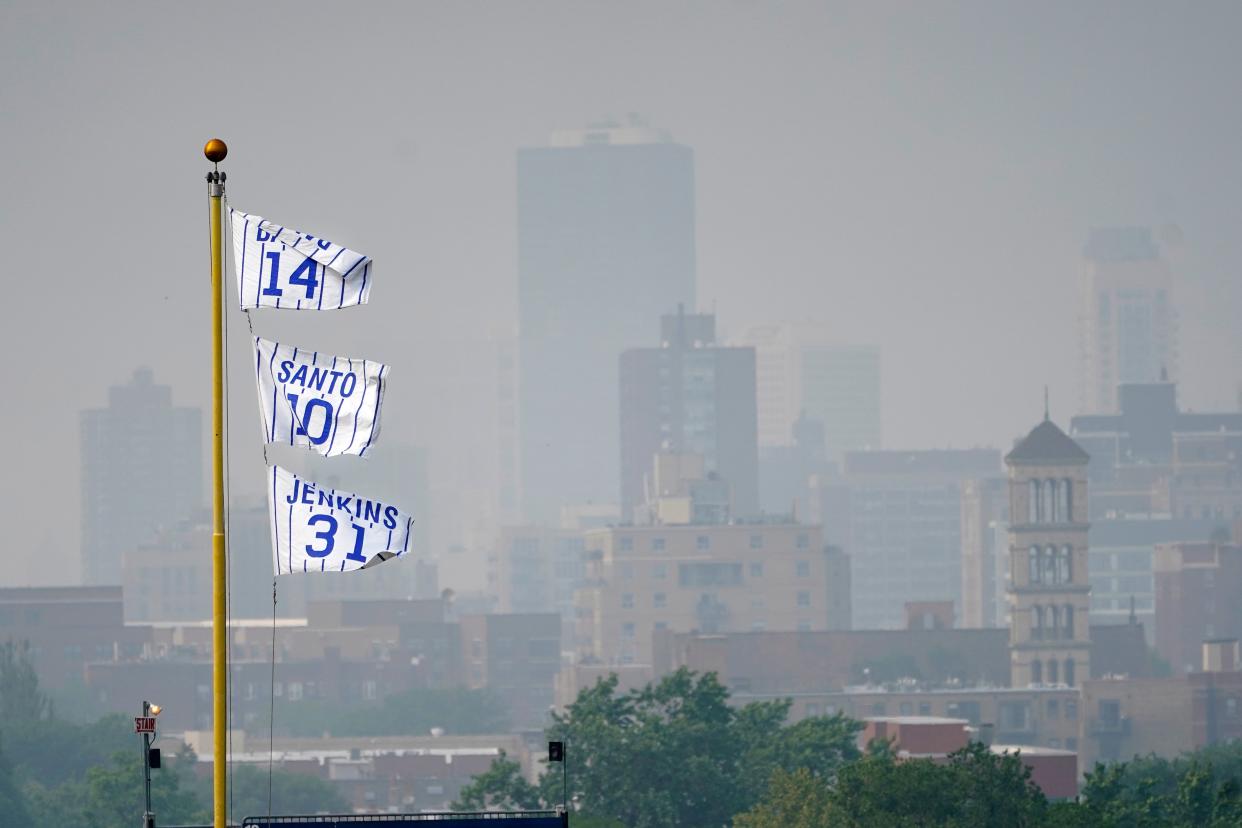 The flags of Chicago Cubs’ Hall of Fame players fly off the Wrigley Field left field foul pole as a veil of haze from Canadian wildfires (AP)