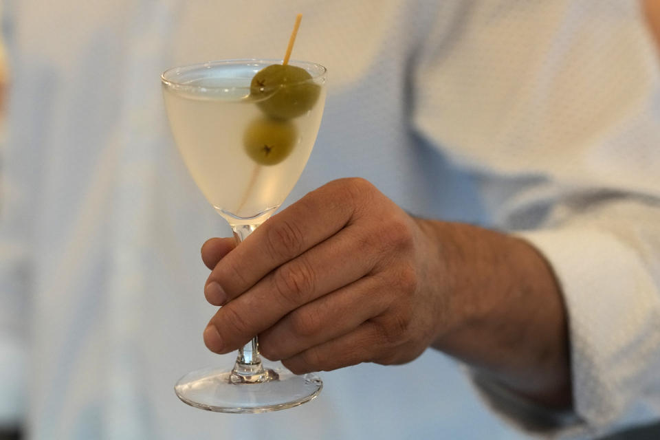 Bartender Brian McGee holds a Dirty Gin Martini with two olives at the Koval Distillery's tasting room Wednesday, Feb. 8, 2023, in Chicago. Spirits have surpassed beer for U.S. market share supremacy, led by a resurgent cocktail culture including the popularity of ready-to-drink concoctions according to the Distilled Spirits Council of the United States. (AP Photo/Charles Rex Arbogast)