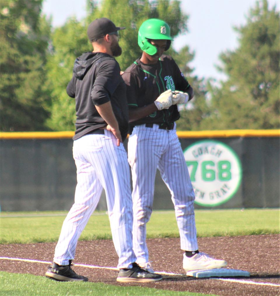 Badin head coach Brion Treadway talks to freshman Chandler Taylor after Taylor hit a two-run triple, as Hamilton Badin defeated Hebron Lakewood in an OHSAA Division II baseball regional semifinal game June 1, 2023, at Mason High School.