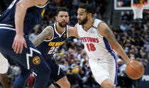 Detroit Pistons guard Cory Joseph, right, drives the lane past Denver Nuggets guard Austin Rivers in the first half of an NBA basketball game Sunday, Jan. 23, 2022, in Denver. (AP Photo/David Zalubowski)