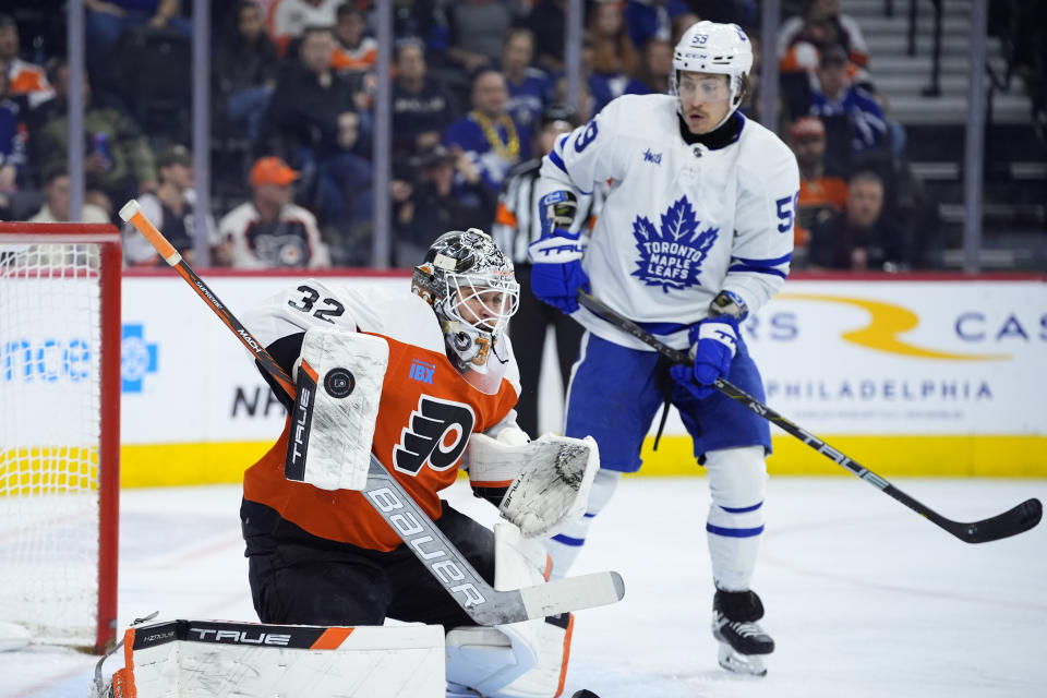 Philadelphia Flyers' Felix Sandstrom, left, blocks a shot as Toronto Maple Leafs' Tyler Bertuzzi looks on during the third period of an NHL hockey game, Thursday, March 14, 2024, in Philadelphia. (AP Photo/Matt Slocum)