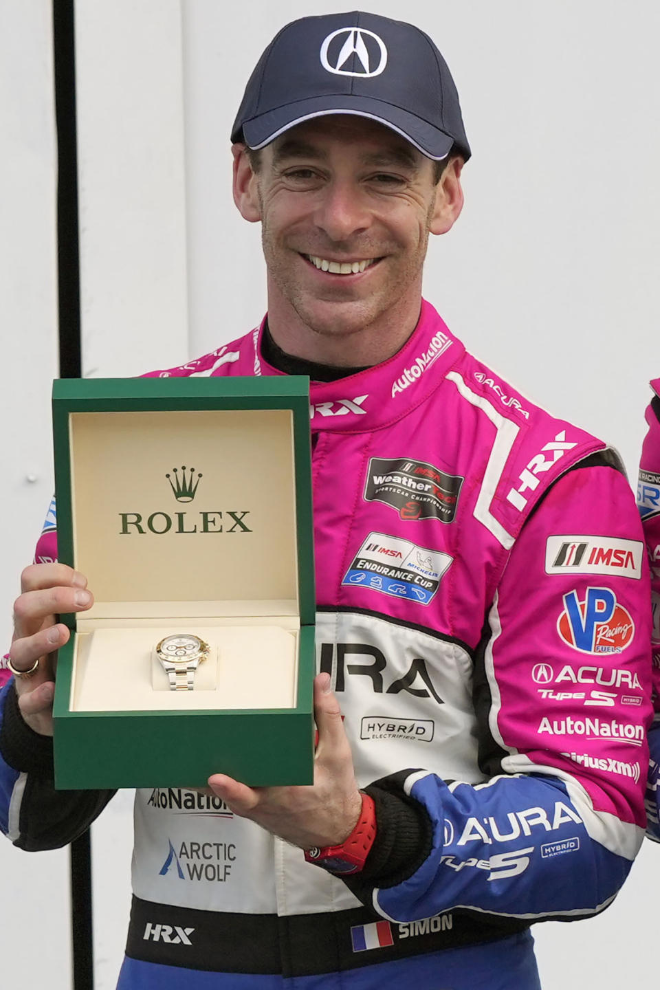 FILE - Simon Pagenaud shows off his Rolex watch in Victory Lane after the Rolex 24 Hour race at Daytona International Speedway, Sunday, Jan. 29, 2023, in Daytona Beach, Fla. Simon Pagenaud won back-to-back Rolex watches driving for a team that isn't at Daytona International Speedway to defend its two titles in the prestigious endurance race. But Pagenaud could not have driven anyway: the Frenchman is still recovering from injuries suffered in a July crash during IndyCar practice. (AP Photo/John Raoux, File)