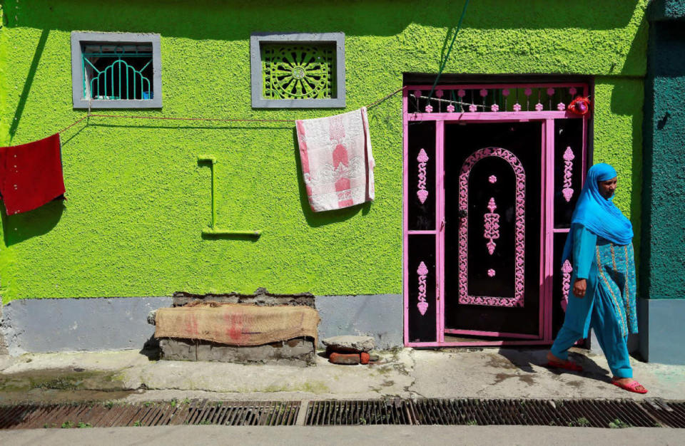 A woman steps outside her house in Srinagar as the city remains under curfew following weeks of violence in Kashmir