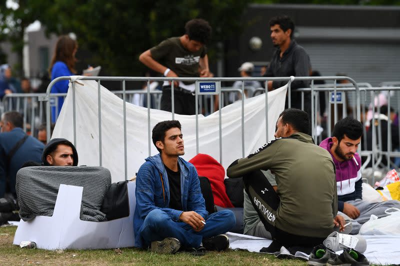 Refugees wait outside at the main reception centre for asylum seekers, in Ter Apel