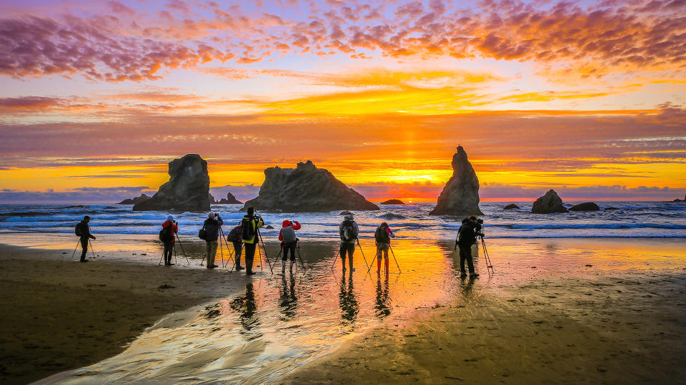 Bandon Beach-Oregon State, June 02 2017 : A group of photographers taking photos of the rock formations and sun setting on Bandon Beach, USA.