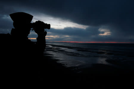 A French gendarme patrols the beach just after sunset in Wissant, France, January 11, 2019. Picture taken January 11, 2019. REUTERS/Pascal Rossignol