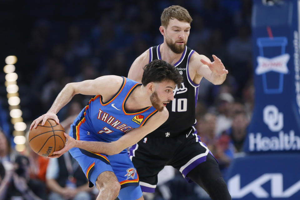 Oklahoma City Thunder forward Chet Holmgren (7) holds the ball away from Sacramento Kings forward Domantas Sabonis (10) during the first half of an NBA basketball game Tuesday, April 9, 2024, in Oklahoma City. (AP Photo/Nate Billings)