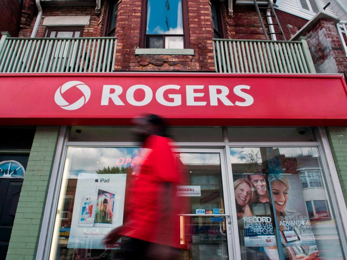 A man walks by a Rogers store in Toronto, Wednesday, August 15, 2013. Rogers Communications is experiencing a widespread outage that's affecting many services across the country, including Interac. (Galit Rodan/The Canadian Press - image credit)