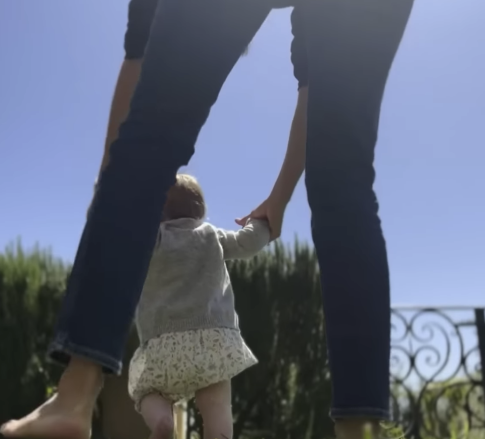 Lilibet seen from behind as she's held while walking