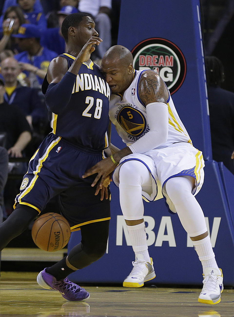 Golden State Warriors' Marreese Speights, right, loses the ball as he runs into Indiana Pacers' Ian Mahinmi (28) during the first half of an NBA basketball game, Monday, Jan. 20, 2014, in Oakland, Calif. (AP Photo/Ben Margot)