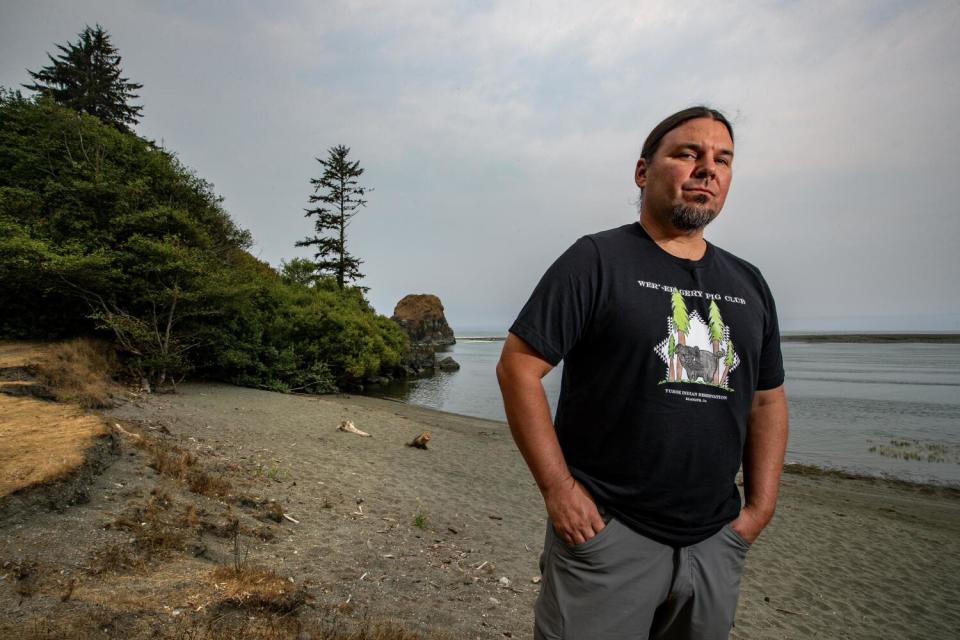 A man stands at the mouth of a river.