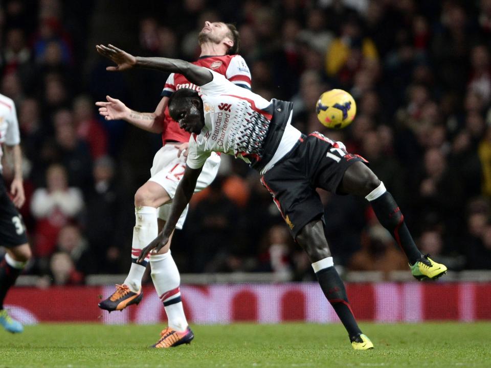 Arsenal's Giroud challenges Liverpool's Sakho during their English Premier League soccer match at the Emirates stadium in London