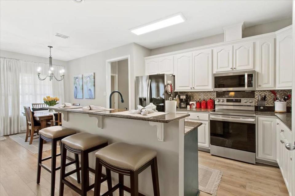 The kitchen of this house for sale on Rue Beaux Chenes in Ocean Springs features a separate breakfast area that is part of an open-concept living area.