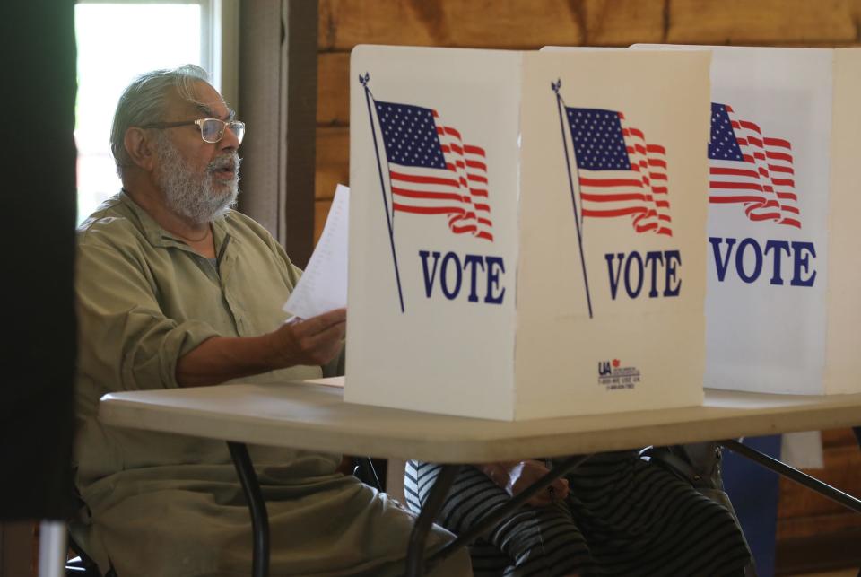 Naresh Chawla looks at his ballot for the primary election.  He and his wife, Raj, came out to vote at the Carmen Clark Lodge in Brighton.  