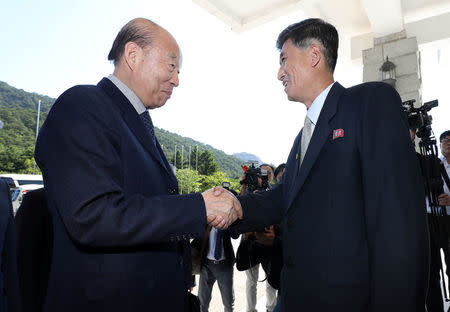 South Korea's delegation leader Park Kyung-seo, head of the Korean Red Cross, is greeted by North Korea's delegation leader Pak Yong-il, vice chairman of the Committee for the Peaceful Reunification of the Country, at a hotel on Mount Kumgang, North Korea, June 22, 2018. Yonhap via REUTERS ATTENTION EDITORS - THIS IMAGE HAS BEEN SUPPLIED BY A THIRD PARTY. SOUTH KOREA OUT. NO RESALES. NO ARCHIVE.