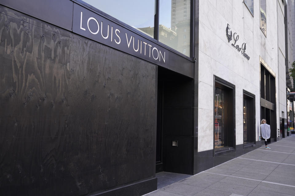 A large window of the Louis Vuitton store is seen boarded up following a recent robbery at Union Square in San Francisco, Thursday, Dec. 2, 2021. In San Francisco, homeless tents, open drug use, home break-ins and dirty streets have proliferated during the pandemic. (AP Photo/Eric Risberg)