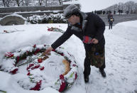A man places a piece of bread at a bed of honor at the Piskaryovskoye Cemetery where most of the Leningrad Siege victims were buried during World War II, in St.Petersburg, Russia, Saturday, Jan. 26, 2019. People gathered to mark the 75th anniversary of the battle that lifted the Siege of Leningrad. The Nazi German and Finnish siege and blockade of Leningrad, now known as St. Petersburg, was broken on Jan. 18, 1943 but finally lifted Jan. 27, 1944. More than 1 million people died mainly from starvation during the 900-day siege. (AP Photo/Dmitri Lovetsky)
