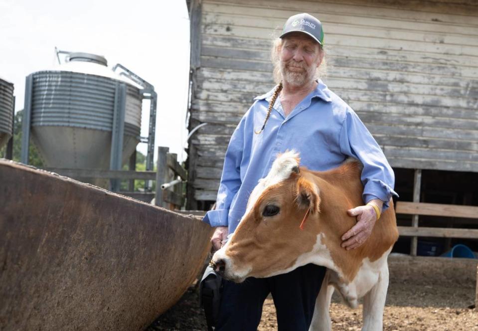 Randy Lewis smiles as he hugs one of his cows at Ran-Lew Dairy Farm in Snow Camp, N.C. on Friday, June 16, 2023. Lewis spent 26 days in the hospital after being attacked by a black Angus bull on his farm last month. He returned home to Ran-Lew Dairy on June 2, where he has continued his recovery.