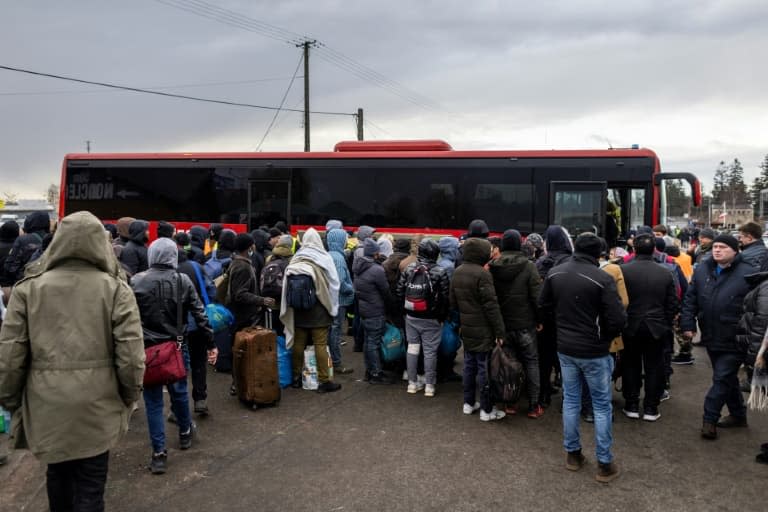 Des réfugiés de différents pays arrivés à pied en Pologne après avoir fui les combats en Ukraine, attendent de monter à bord d'un bus, le 27 février 2022 à Medyka - Wojtek RADWANSKI © 2019 AFP