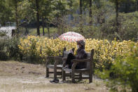 A woman wearing a face mask to help protect against the spread of the coronavirus, sits on a bench while maintaining social distancing at a park in Seoul, South Korea, Monday, Sept. 21, 2020. South Korea’s daily virus tally has stayed below 100 for a second consecutive day, maintaining a slowing trend in fresh infections. (AP Photo/Lee Jin-man)