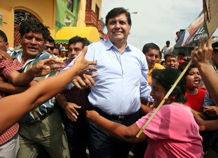 FILE PHOTO: Peruvian presidential candidate Alan Garcia (C) greets supporters during a campaign rally in Catacaos, Piura, Peru May 30, 2006. REUTERS/Mariana Bazo/File Photo