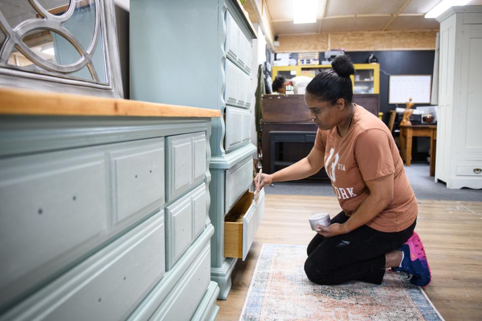 Owner Dominique Villani works on whitewashing a dresser at Cavallo Rosso Designs at 5440 Trade Street in Hope Mills.
