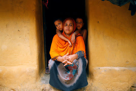 Kulsuma Khatun, 29, whose husband Abu Siddique, chairman of the unregistered camp in Kutupalong, was stabbed by unknown people late last month and is now in hospital, poses for a picture with her two children in Cox’s Bazar, Bangladesh, July 8, 2017. REUTERS/Mohammad Ponir Hossainin