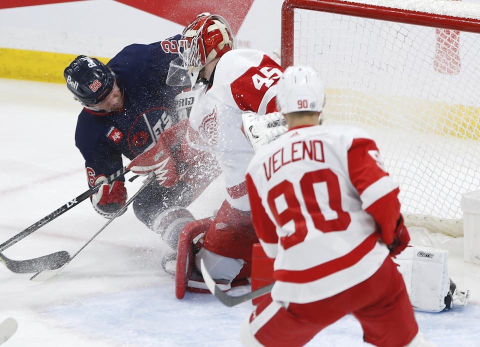 Winnipeg Jets' Blake Wheeler (26) cannot get his shot past Detroit Red Wings goaltender Magnus Hellberg (45) as Red Wings' Joe Veleno (90) defends during second-period NHL hockey game action in Winnipeg, Manitoba, Friday, March 31, 2023. (John Woods/The Canadian Press via AP)