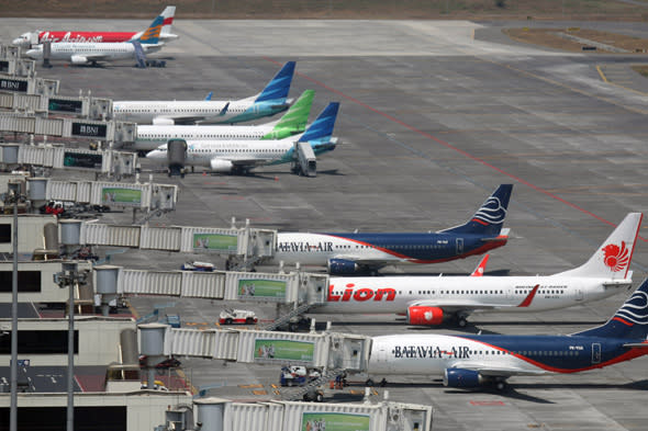 In this Tuesday, Sept. 25, 2012 photo, budget airlines' passenger jets, Malaysia's AirAsia, top, Indonesia's Badavia Air, third from bottom and bottom, and Indonesia's Lion Air, second bottom, are parked on the tarmac with Indonesian planes of domestic airline Merpati Nusantara, second top, and the flagship carrier Garuda Indonesia at Juanda International Airport in Surabaya, East Java, Indonesia. From almost none a decade ago, Asia now has more than 50 low cost carriers. The fast growth of no-frills airlines underline surging demand in the region for affordable air travel. (AP Photo/Trisnadi)