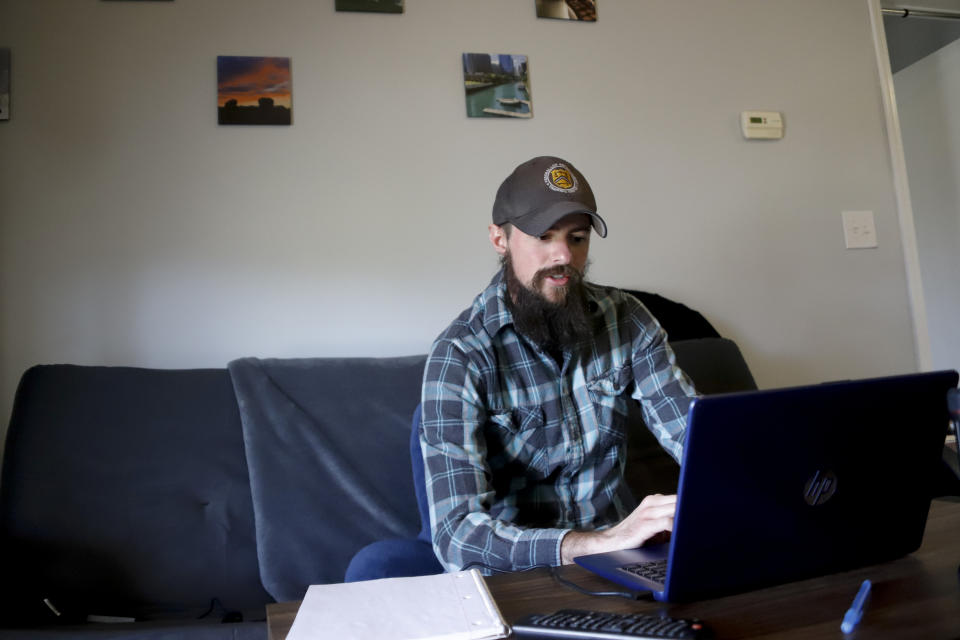 In this Friday, March 13, 2020, photo, Nic Talbott looks over his computer at his home in Lisbon, Ohio. Talbott is a plaintiff in one of four lawsuits filed in federal courts challenging a Trump administration policy barring transgender Americans from enlisting in the military. (AP Photo/Keith Srakocic)