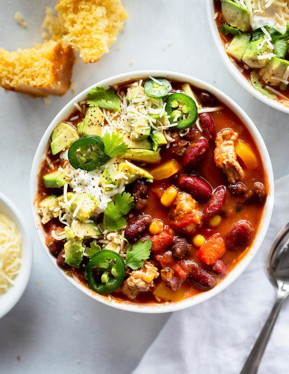 A bowl of turkey chili with toppings.