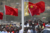 FILE - Spectators hold a Chinese flag as they watch a ceremony to mark the opening of Independence Drive Boulevard in Port Moresby, Papua New Guinea, Friday, Nov. 16, 2018. China wants 10 small Pacific nations to endorse a sweeping agreement covering everything from security to fisheries in what one leader warns is a “game-changing” bid by Beijing to wrest control of the region. (AP Photo/Mark Schiefelbein, Pool, File)