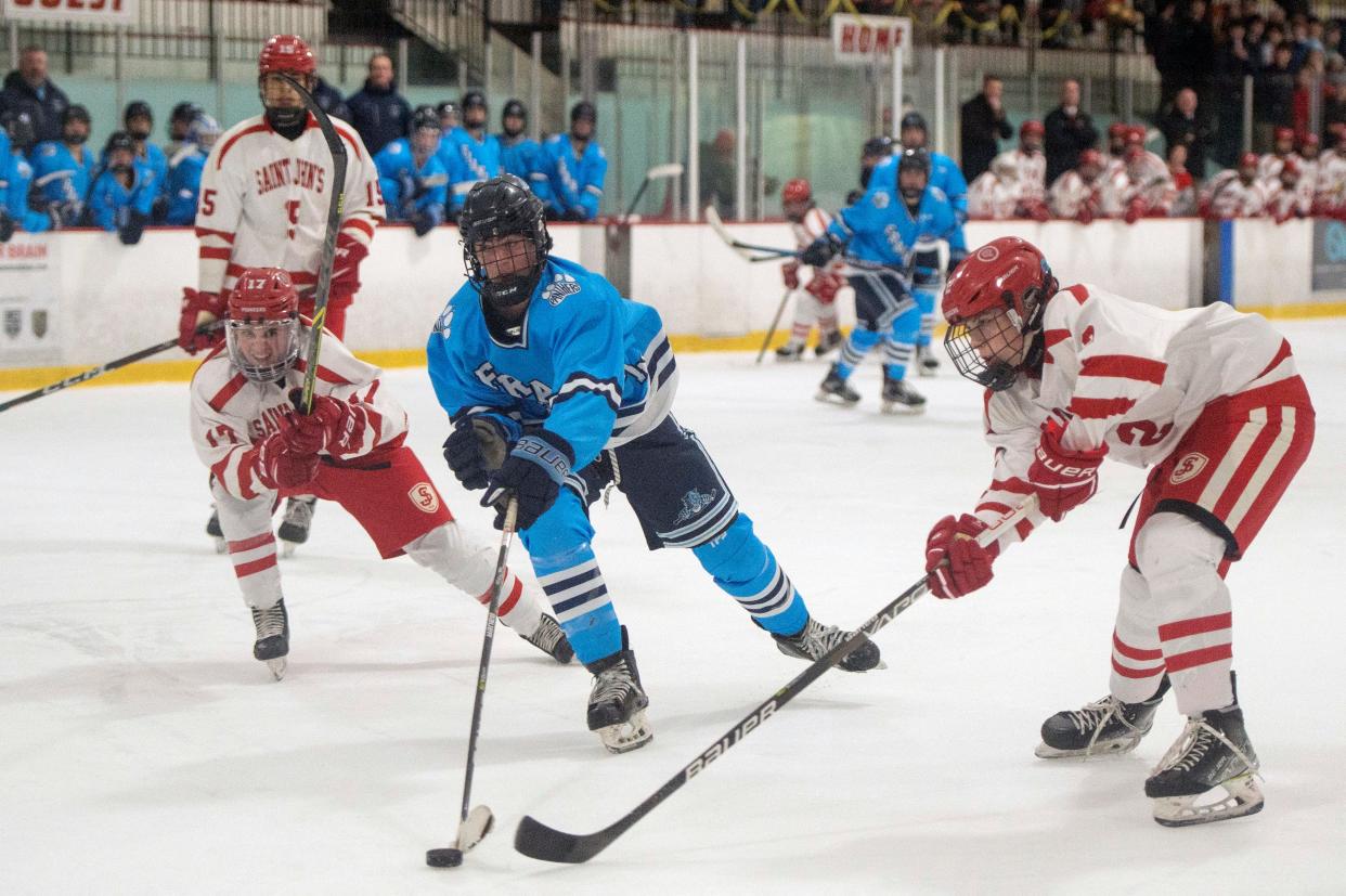 Franklin junior Ben Paterson gets past St. John's sophomore Anthony Desimone and closes in on the net, during the game at the New England Sports Center in Marlborough, Feb. 20, 2022.