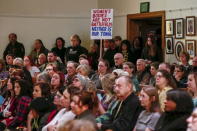 A man holds a sign as people gather for a vigil inside All Souls Unitarian Universalist Church the day after a gunman opened fire on a Planned Parenthood clinic in Colorado Springs, Colorado November 28, 2015. REUTERS/Isaiah J. Downing