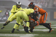 Oregon State running back Jermar Jefferson (6) is brought down Oregon's Kayvon Thibodeaux, back to camera, Noah Sewell, middle, and Jordan Happle (32) by during the second half of an NCAA college football game in Corvallis, Ore., Friday, Nov. 27, 2020. Oregon State won 41-38. (AP Photo/Amanda Loman)