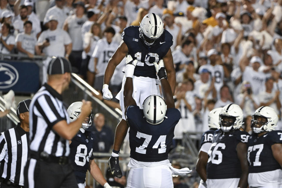 Penn State running back Nicholas Singleton (10) celebrates a touchdown against West Virginia with offensive lineman Olumuyiwa Fashanu (74) during the first half of an NCAA college football game Saturday, Sept. 2, 2023, in State College, Pa. (AP Photo/Barry Reeger)