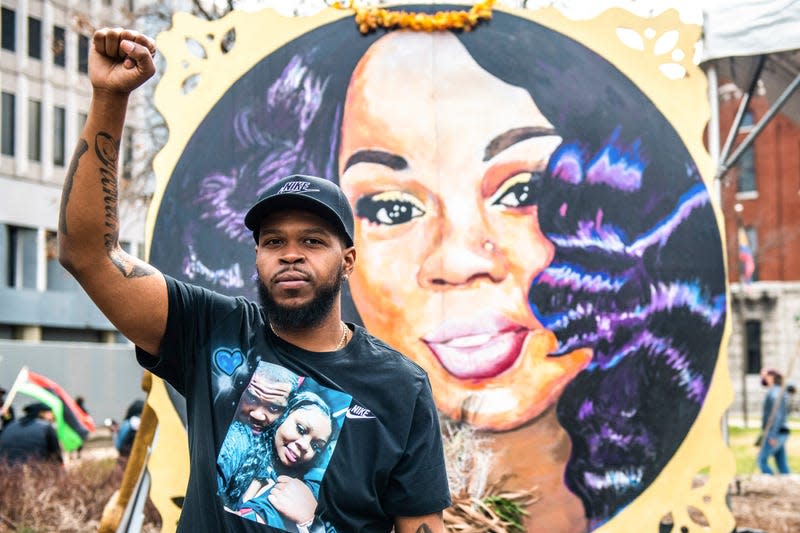 Breonna’s boyfriend, Kenneth Walker poses in front of her painted portrait on the One Year Anniversary of the death of Breonna Taylor on March 13, 2021 in Louisville, Kentucky.